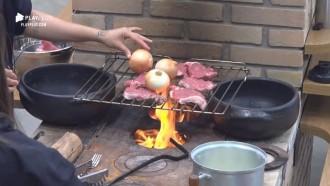 Peões fazem bife de picanha e cebola no fogão a lenha