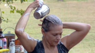 Sem água encanada, Andréa lava a cabeça na área externa
