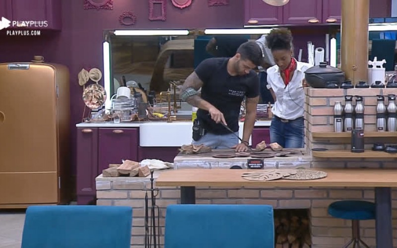 Netto ensina Sabrina Paiva a acender fogão à lenha