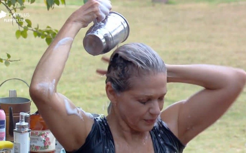 Sem água encanada, Andréa lava a cabeça na área externa