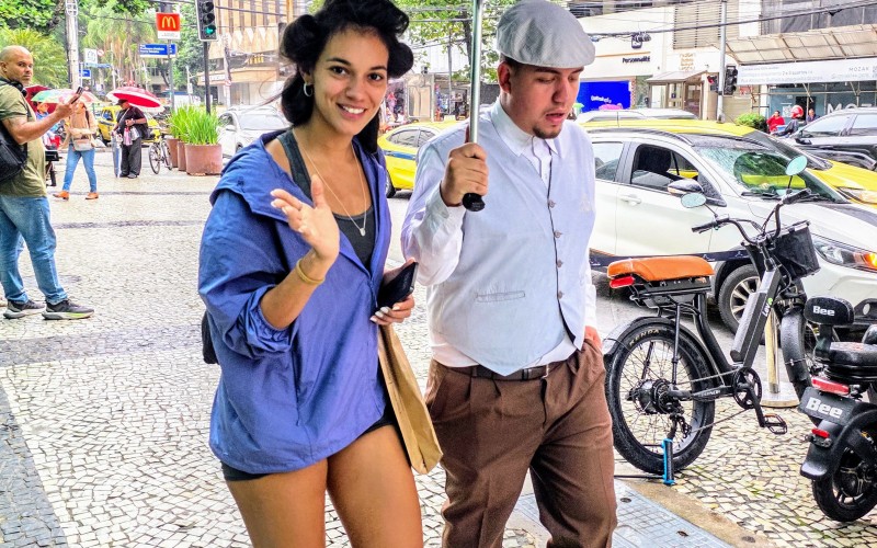 Alane Dias surge de bobs no cabelo pelas ruas do Leblon e pede carona para se proteger da chuva